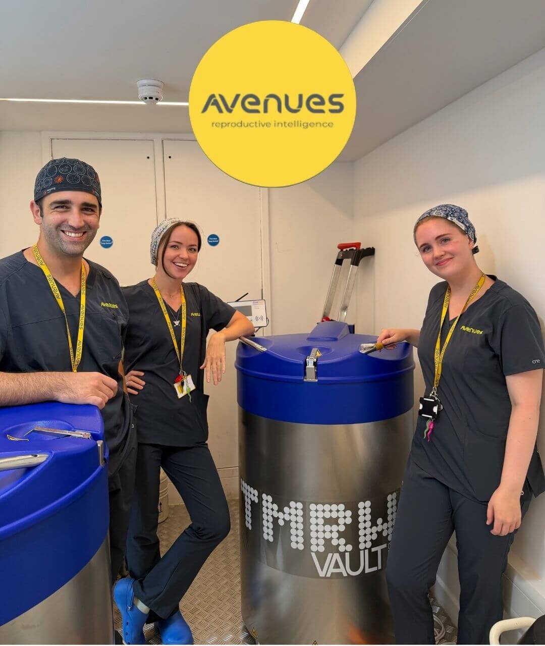 three smiling Avenues fertility clinic embryologists stand adjacent to a cryogenic tank called the TMRW Vault